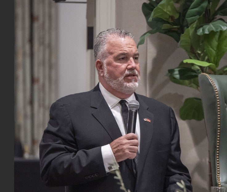 Photo of a gentleman holding a microphone and speaking. (Photo Credit: Wingate Downs)
