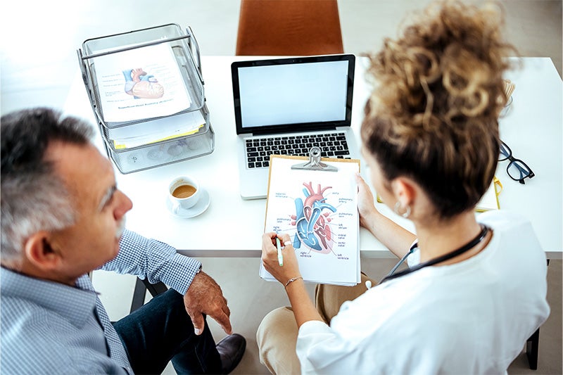 Doctor and patient discussing a diagram of the heart.