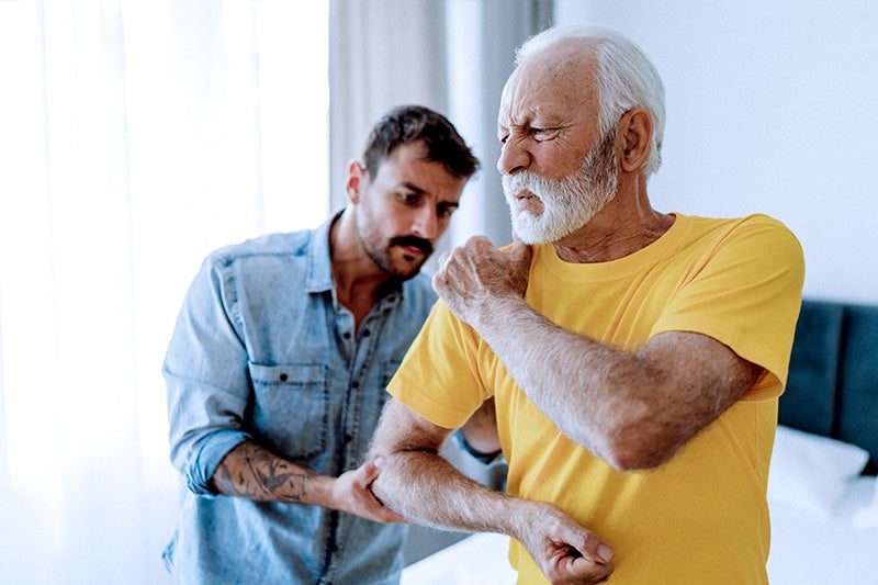 Man complaining about joint pain to a loved one.