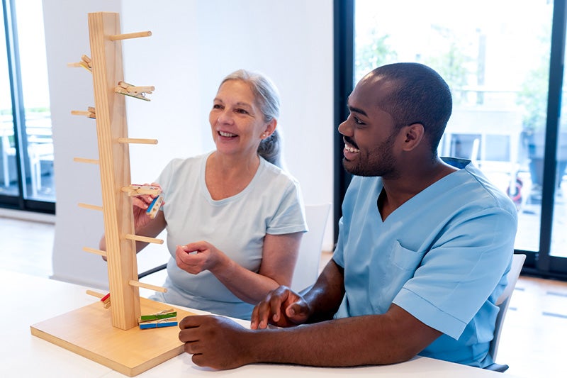 Occupational therapist assisting a patient with fine motor skill exercises.