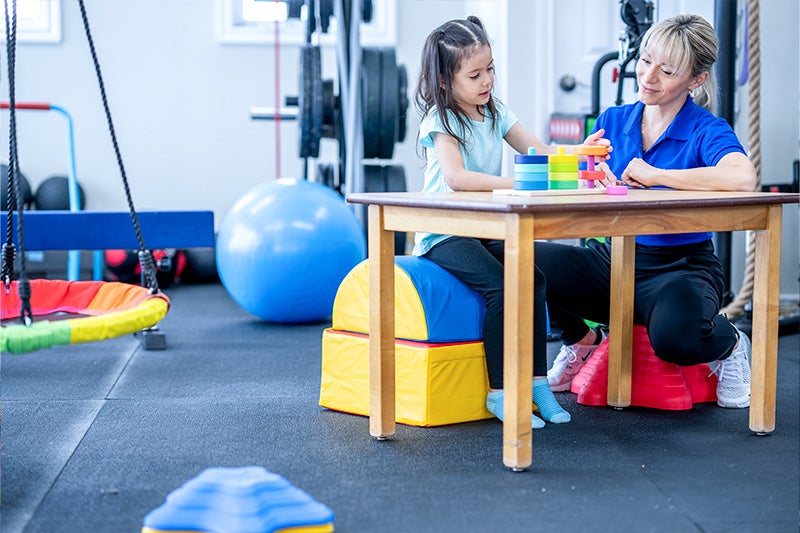 Occupational therapist working with young patient on game to help build sensory processing management techniques.