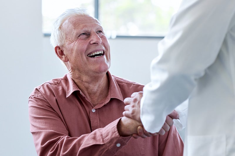Older man shaking hands with a physician.