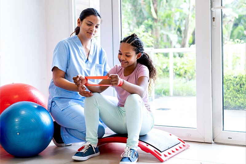 Occupational Therapist working with teenage child.