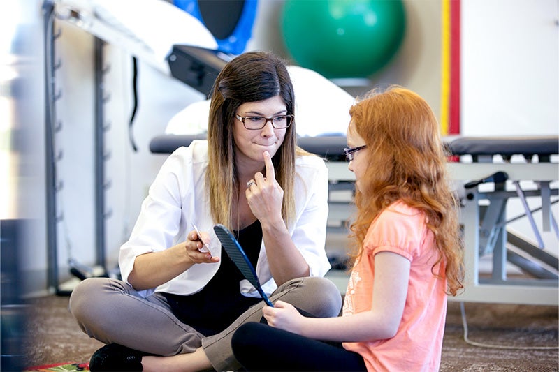 Speech-language pathologist working with a pediatric patient.