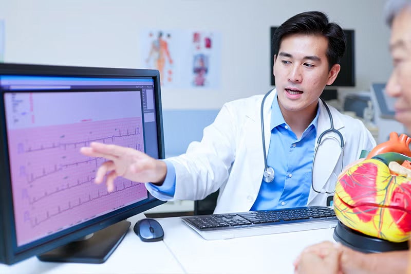 Photograph of a physician looking at electrophysiology lab results.