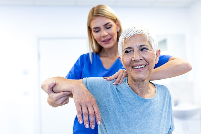 Physical therapist assisting a orthopedic rehabilitation patient with exercises to aid in recovery.