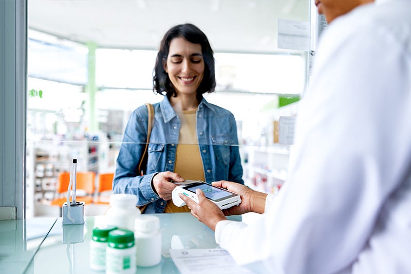 St. Mary's Community Pharmacy Pharmacist helping a patient pay for their medication.