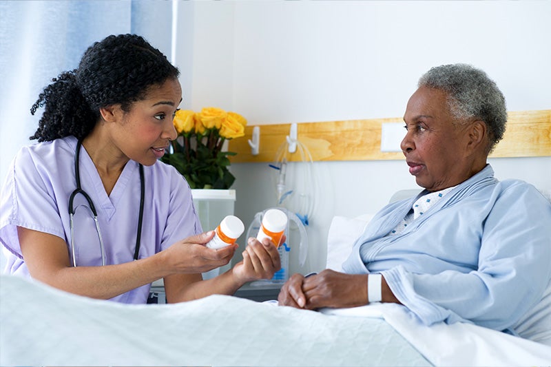 St. Mary's Community Pharmacy Pharmacist delivering medication to a patient and explaining medication information.