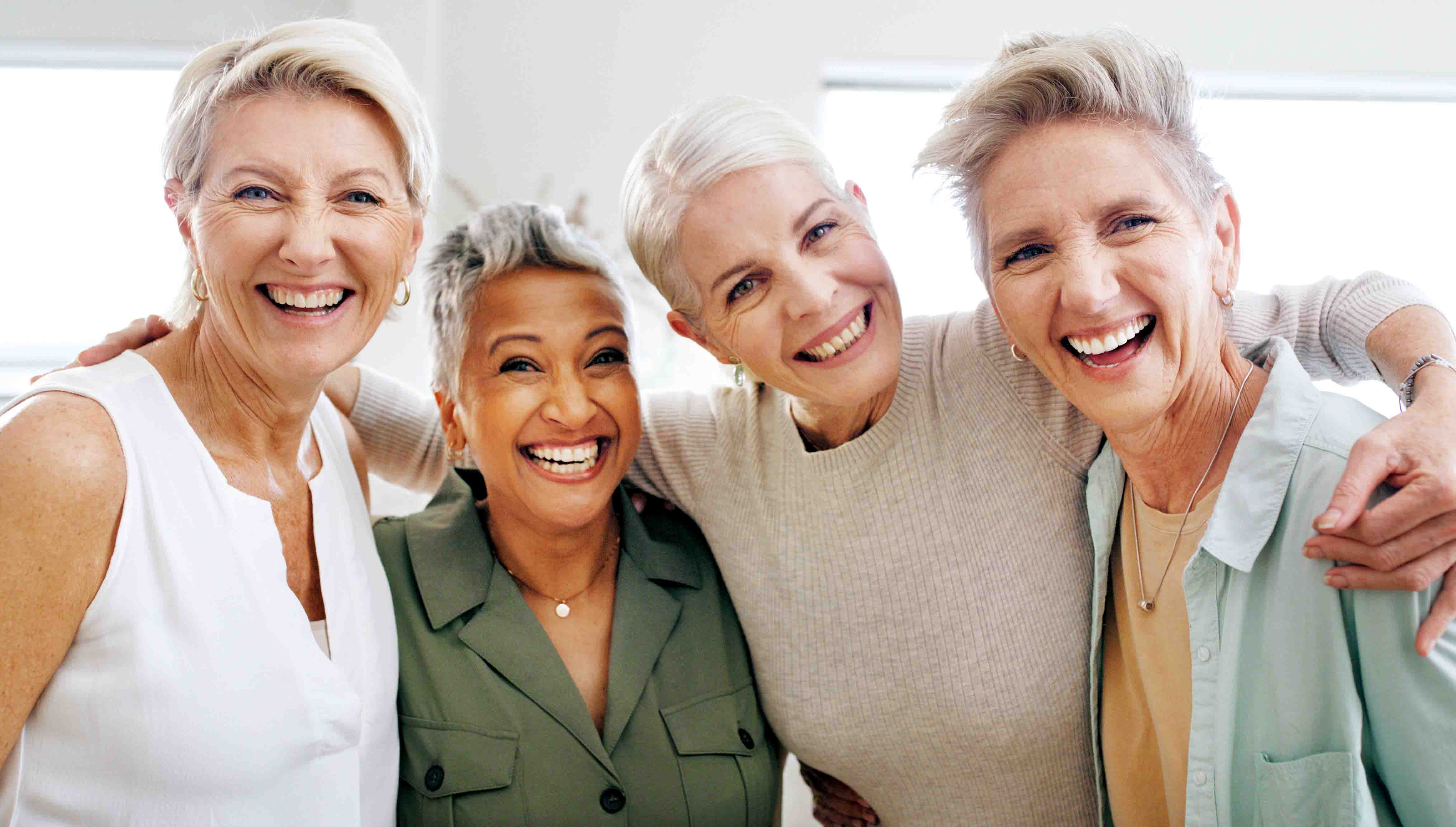 A group of women laughing and smiling at the camera.