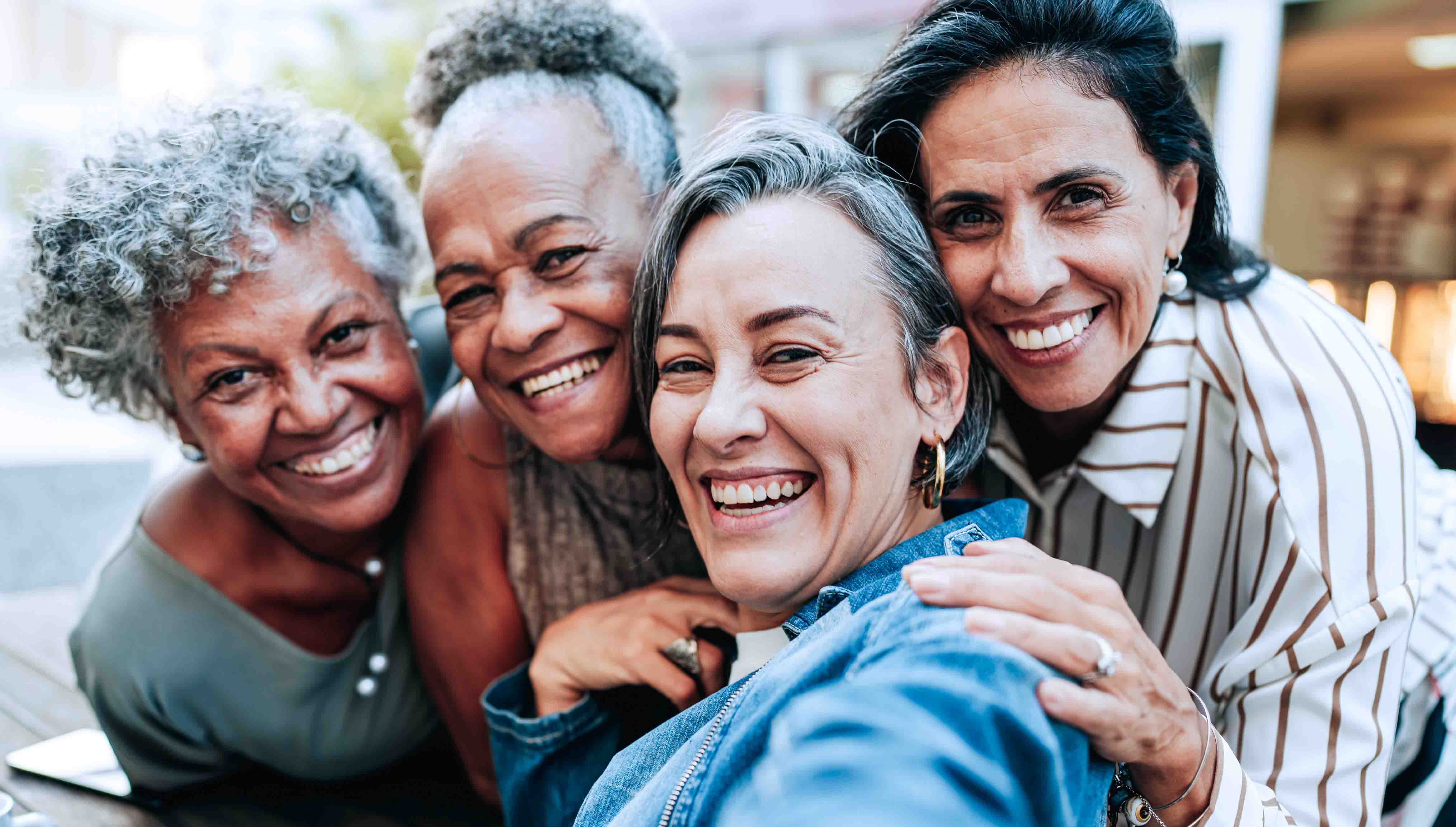 Group of women of perimenopausal age smiling at the camera.