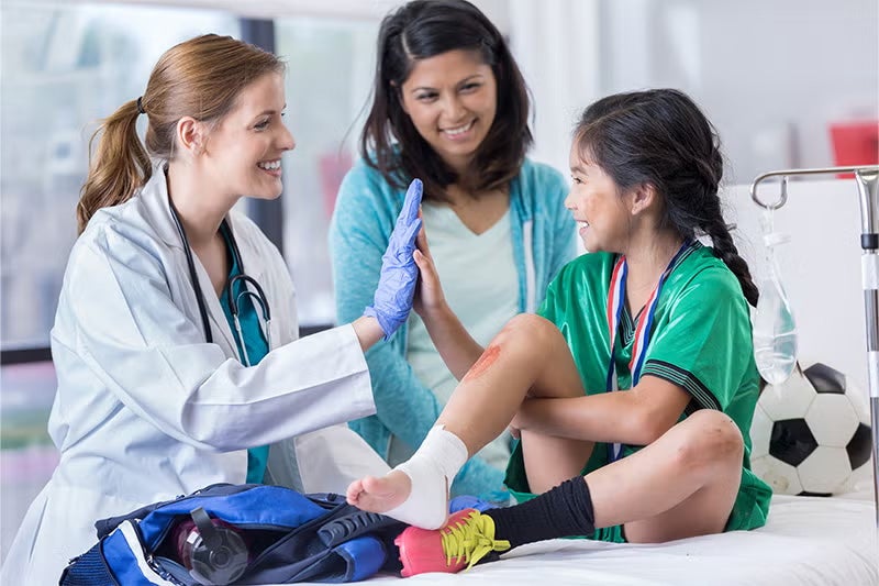Physician speaking to a pediatric patient who has suffered a wound.