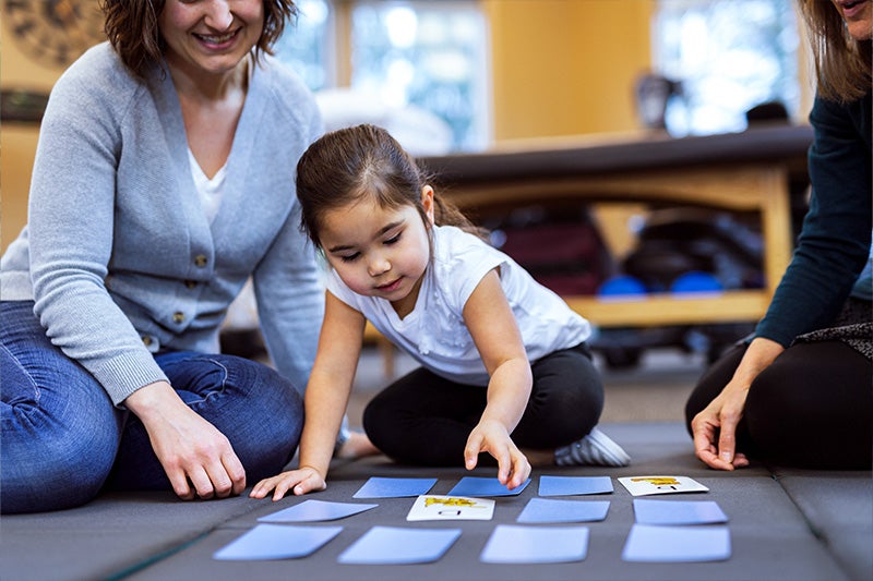 Mother and child playing games on the floor together.