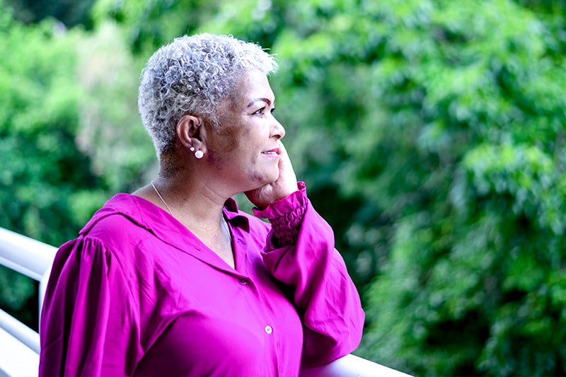 Woman leaning against a wall after a walk.