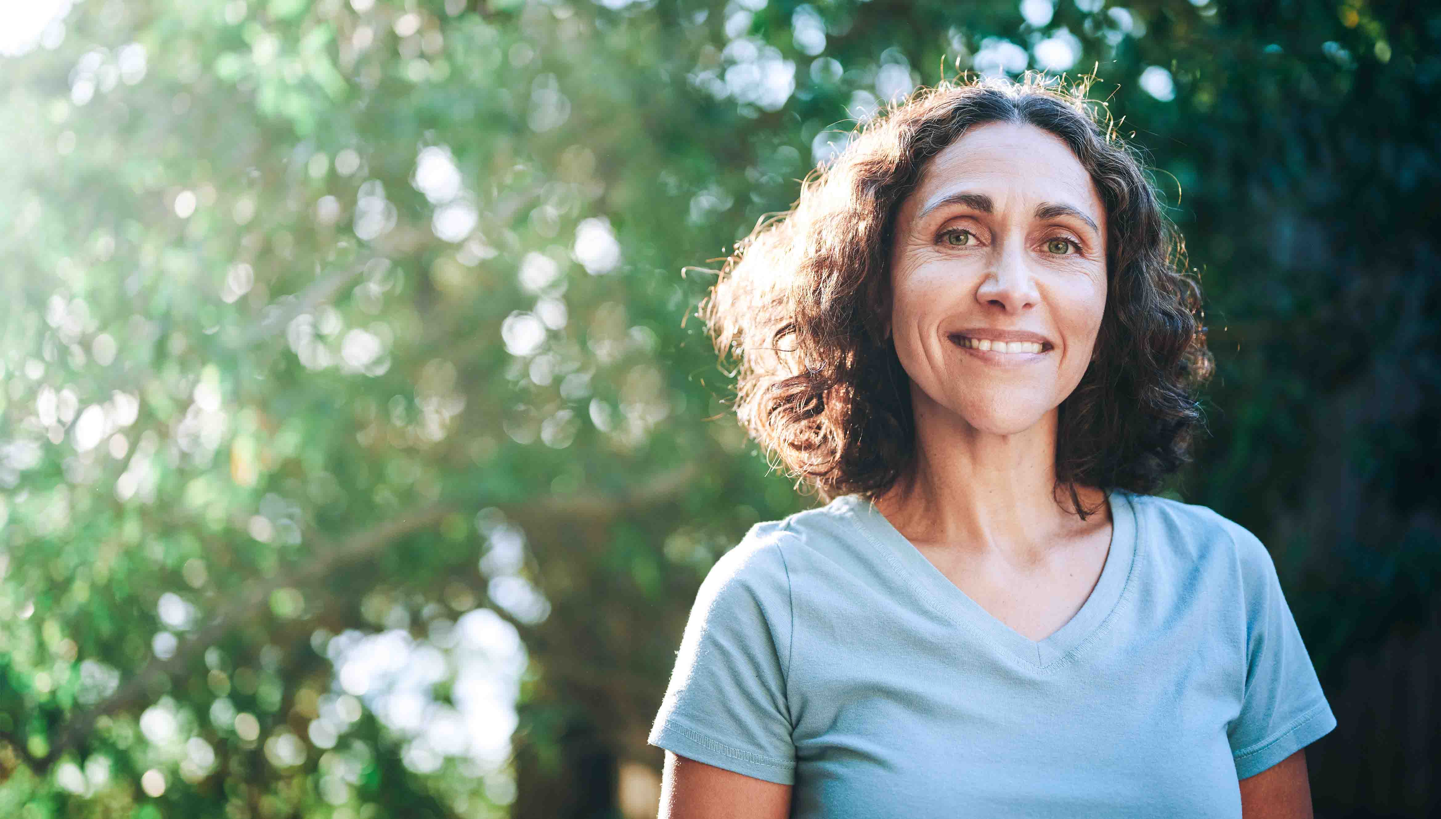 Woman smiling at the camera after getting her indoor allergy symptoms under control.